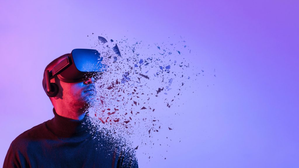 Un homme porte un casque VR et regarde vers le haut sur un fond violacé. Il se décompose en petits morceaux qui partent vers la droite.