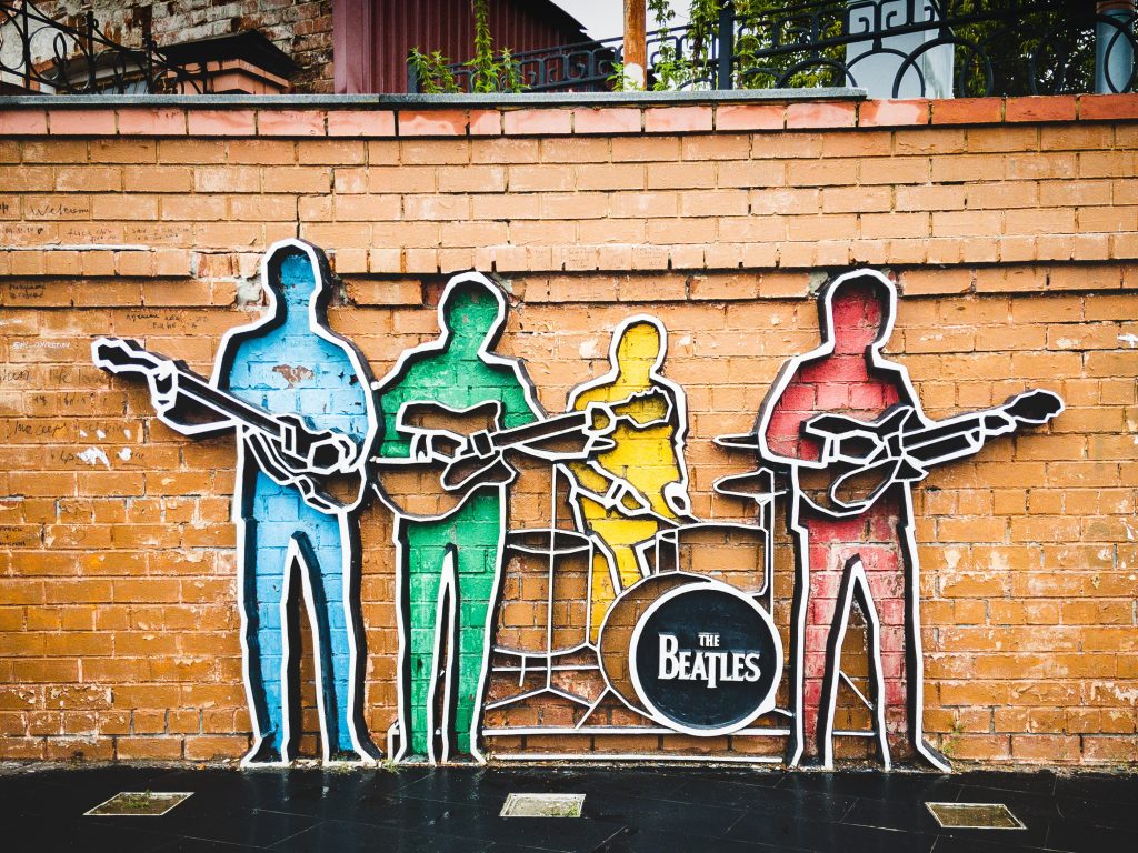 Œuvre d'art murale montrant les silhouettes des Beatles. Chaque membre du groupe est d'une couleur différente.