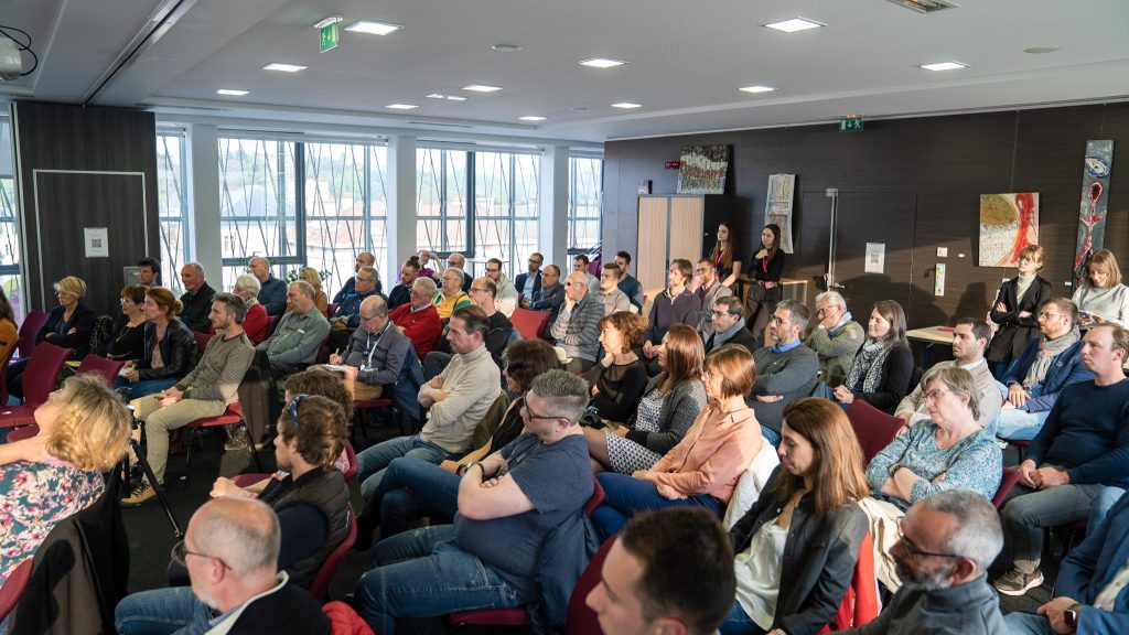 De nombreuses personnes assistent à une conférence Quai Alpha