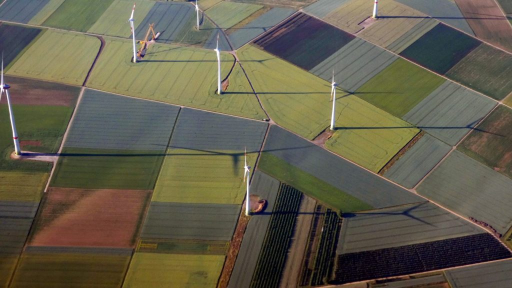une vue aérienne de champs parsemés d'éoliennes
