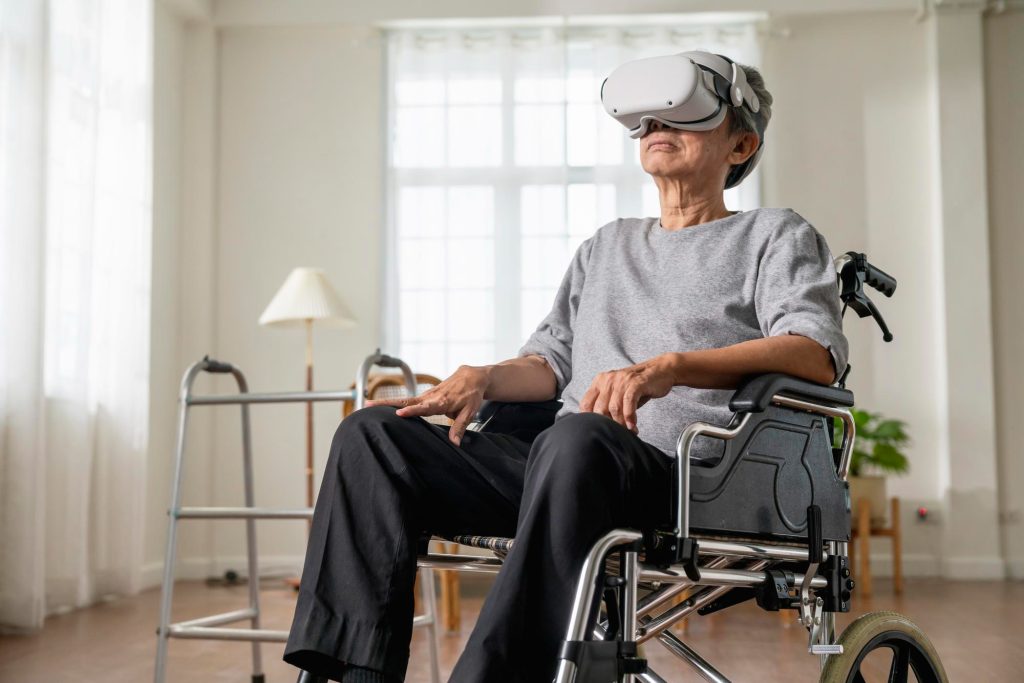 Un homme âgé en fauteuil roulant pourte un casque VR
