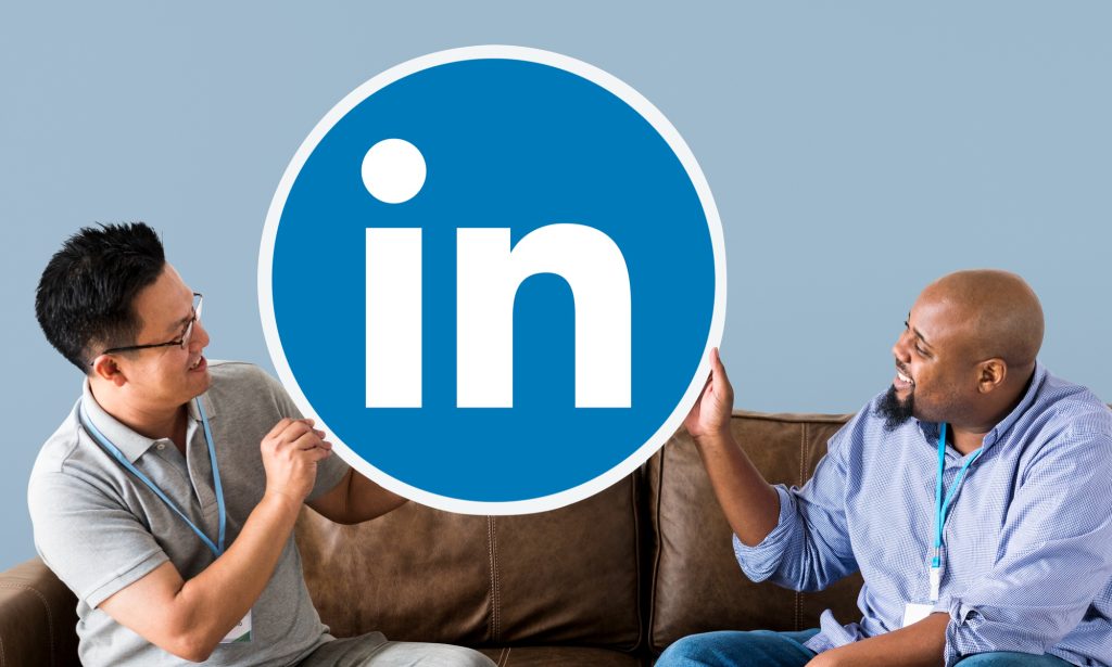 Deux personnes sur un canapé tiennent un logo LinkedIn circulaire