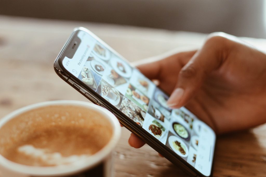 Une main tenant un smartphone ouvert sur l'application Instagram