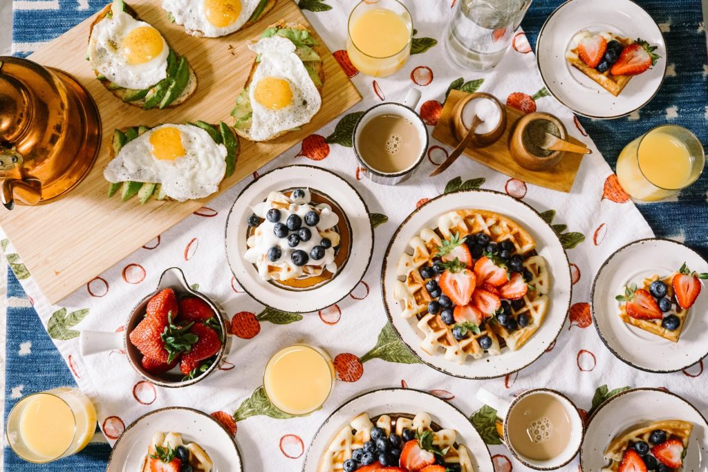 Photo vue de dessus d'une table de petit déjeuner avec divers aliments sucrés et salés ainsi que des boissons